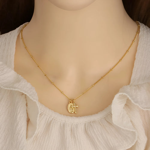 Geometric Virgin Mary and cross pendant necklace in 18K gold colour on a copper chain.