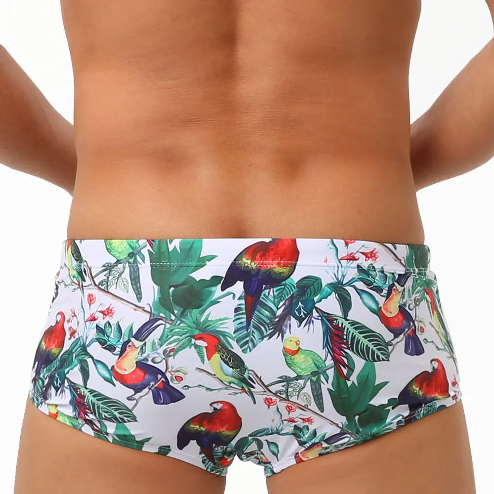 Men's navy blue swimming trunks with colourful flower and bird print pattern.