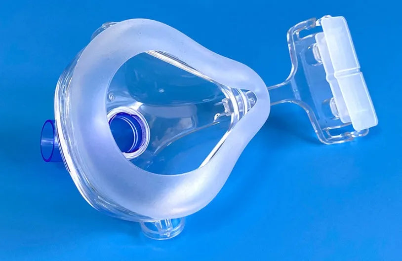 Transparent CPAP breathing mask with silicone cushion, headgear, and adapter elbows