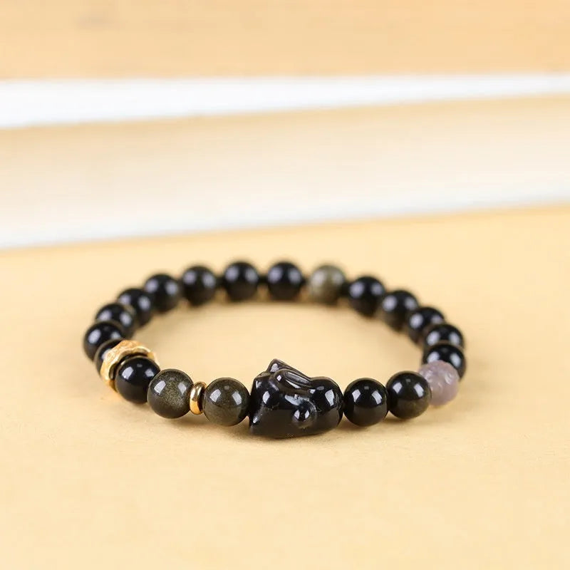Handmade national style bracelet with a lying rabbit charm, grey agate, and metal details on a wrist.
