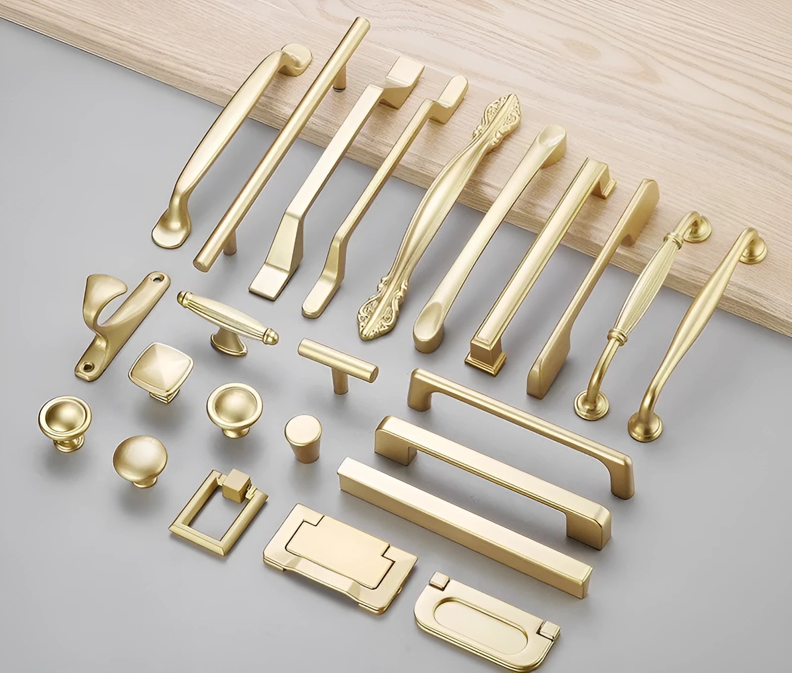 Gold coloured aluminium T-shaped single hole cabinet door handle on white background