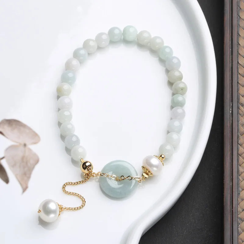 Natural green jade and pearl bracelet with peace buckle closure on wrist