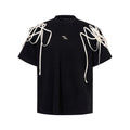 Black loose fit short sleeve t-shirt with rivet ribbon detail on padded shoulders.