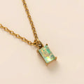 Titanium steel necklace with rectangular birthstone pendant and adjustable O-link chain on a neutral background.