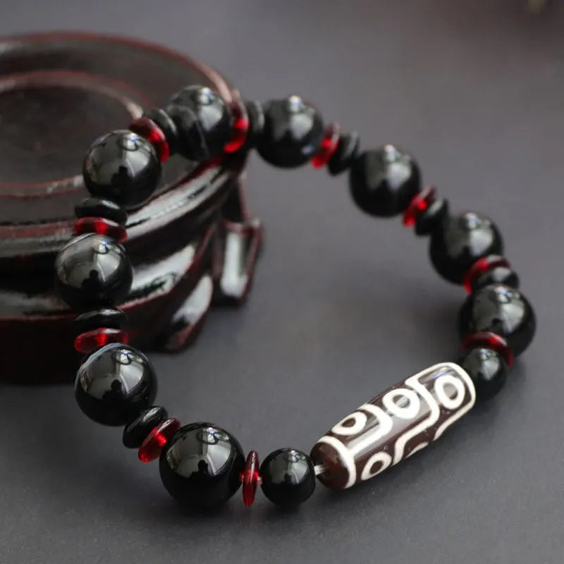 Black agate dzi bead bracelet with hand-woven construction and geometric 11mm beads