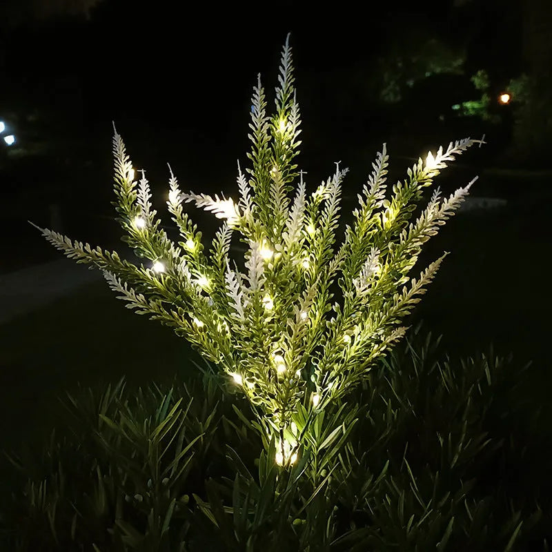 74cm tall pink lavender-shaped solar garden light with green stem, placed in a garden bed.