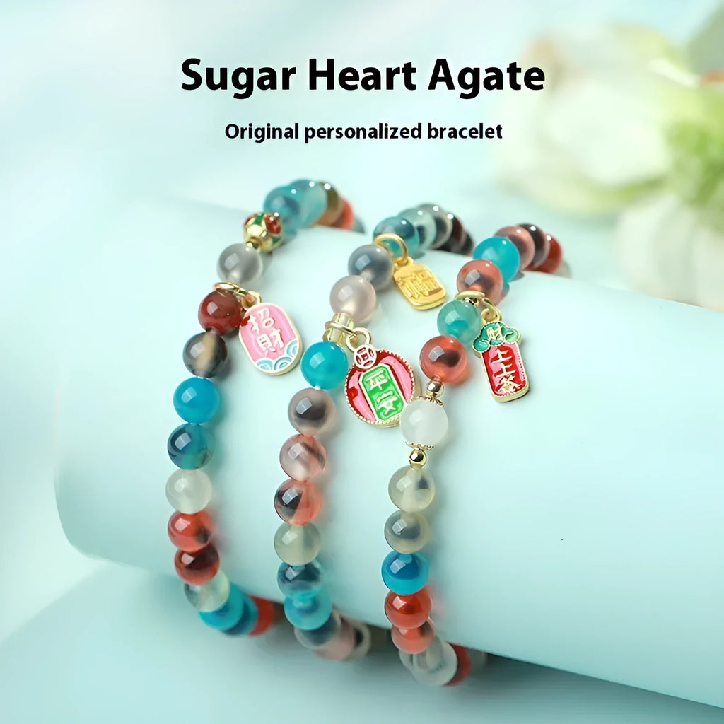 Natural agate and coloured glaze snake bracelet with copper coin charms on a white background.