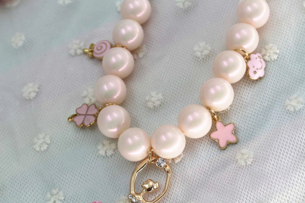 Children's Korean style pearl necklace in Symphony Pink, laid flat on white background