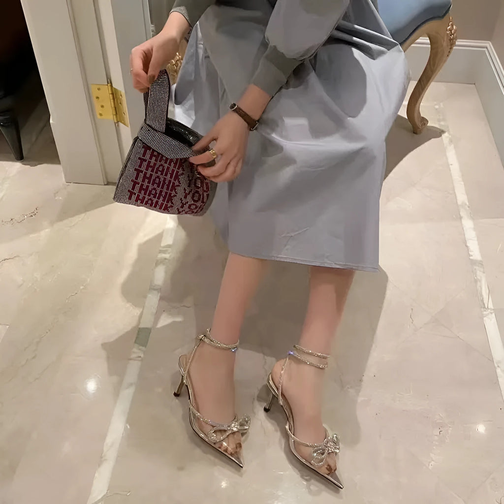 Women's black stiletto heel sandals with a silk bandage across the back and a buckle strap.