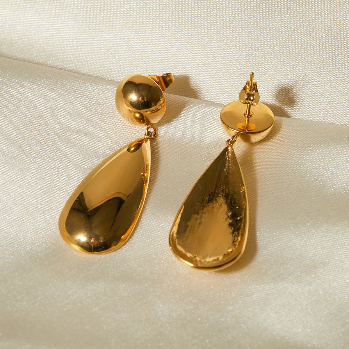Gold electroplated stainless steel earrings with geometric hemisphere water drop pendant design