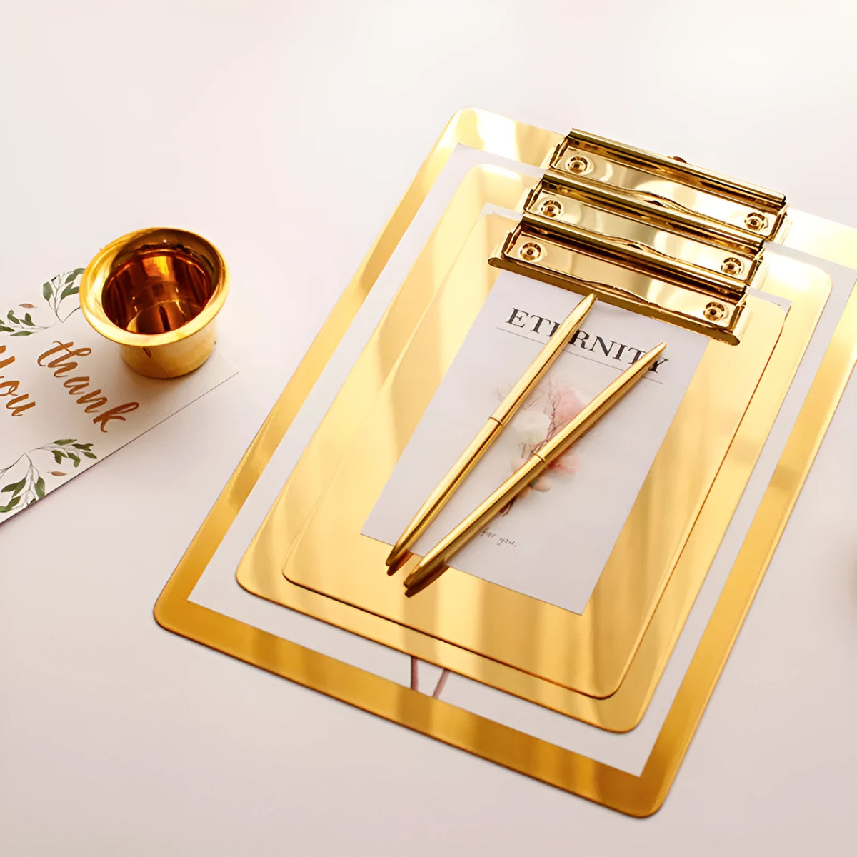 Gold metal-plated stainless steel folder board for office and study use on a flat surface.