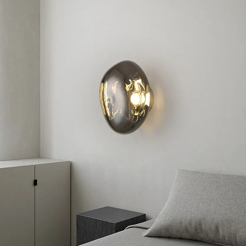 Modern creative lava wall lamp with acrylic shade, 30x18cm, gold finish, on a wall emitting warm light
