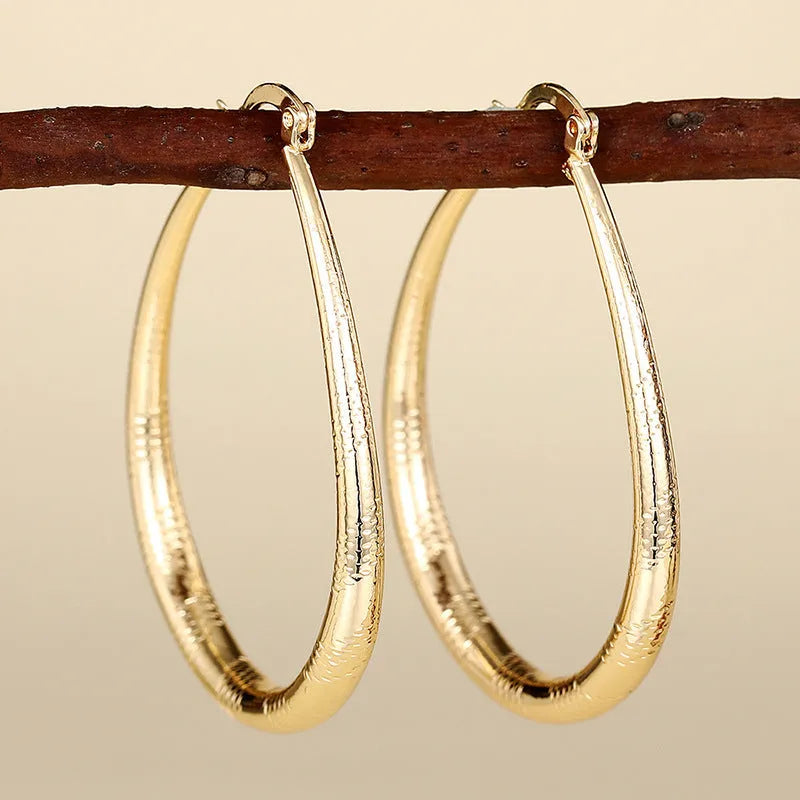 Women's geometric ring design ear clips in copper with electroplated finish showing drop-shaped silhouette