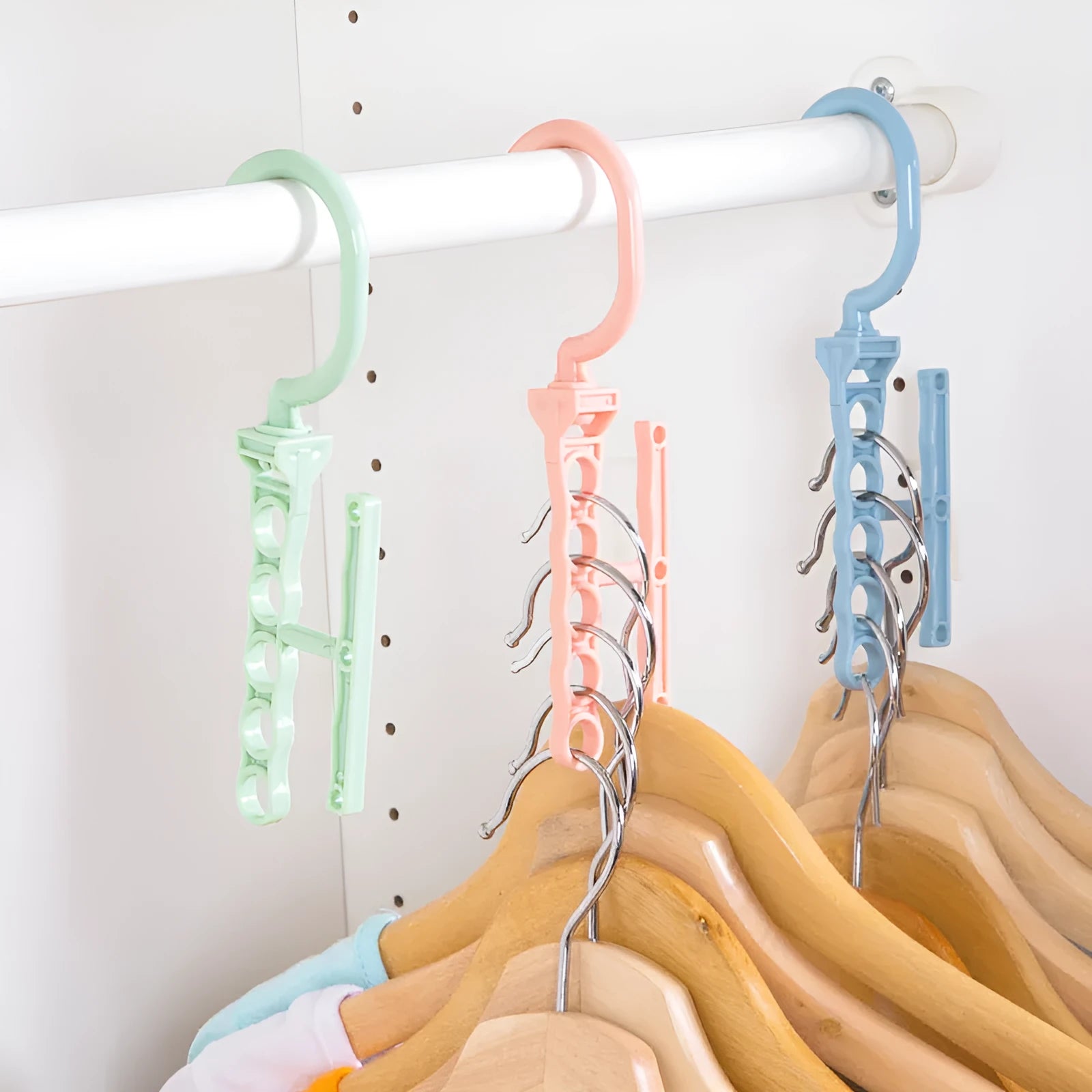 Blue revolving plastic wardrobe hanger with five holes and a top handle on a white background.