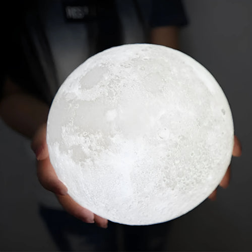 3D printed white moon lamp with detailed craters on a wooden stand, showing touch ring at base