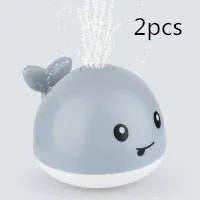 White and blue whale bath toy spraying water with LED lights illuminated