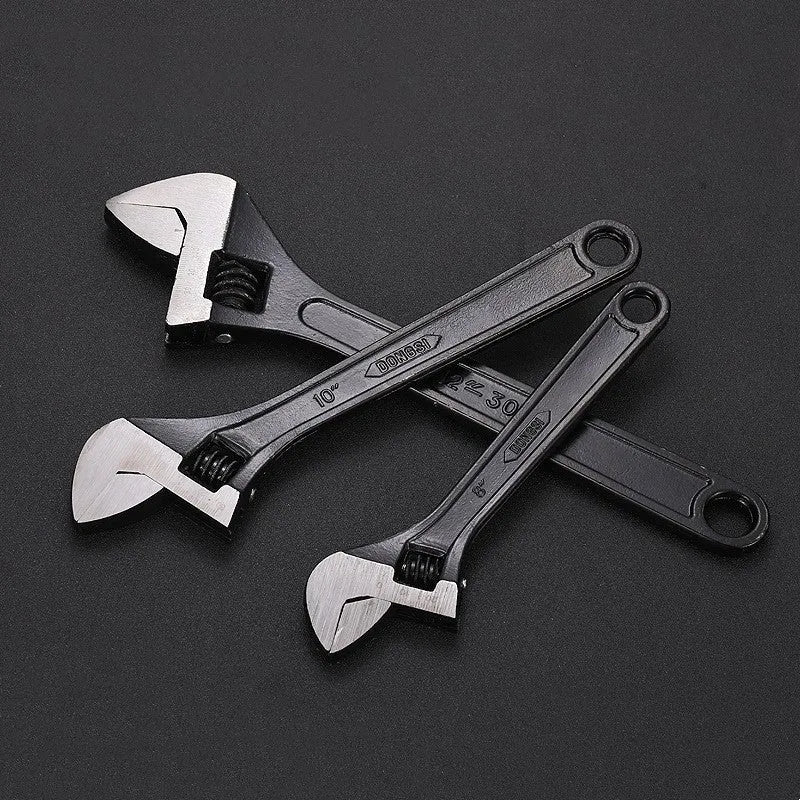 10-inch black high carbon steel adjustable open-end wrench on a workbench.
