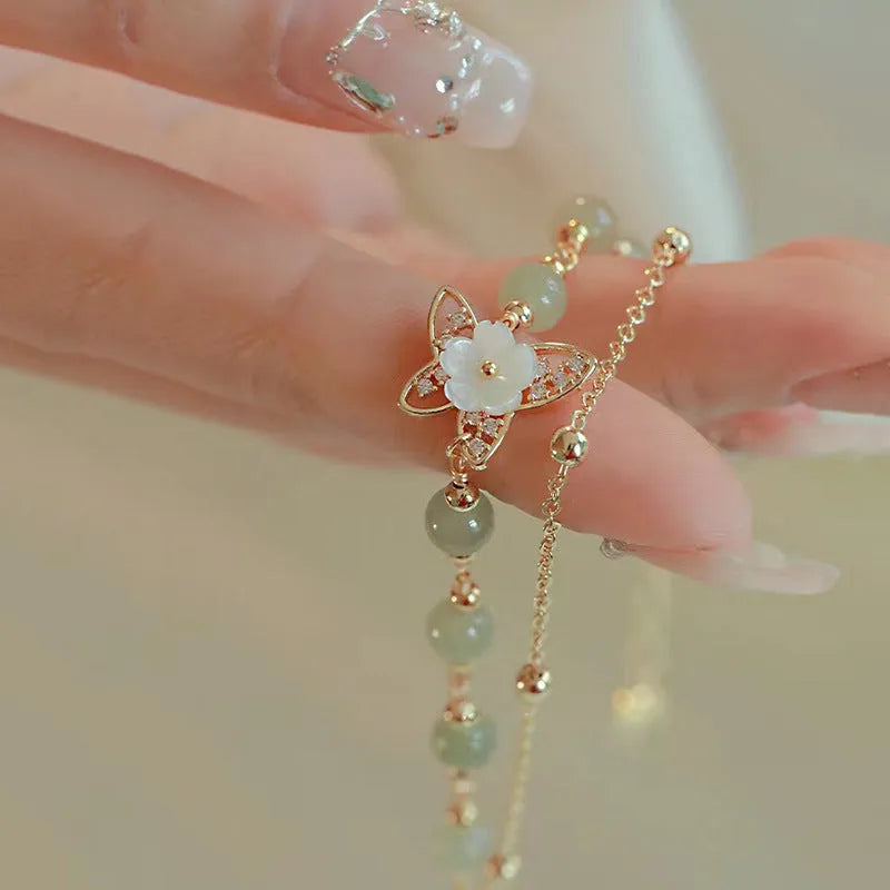 Women's yellow gold electroplated copper butterfly bracelet with geometric shell flower design and Hetian jade stone.
