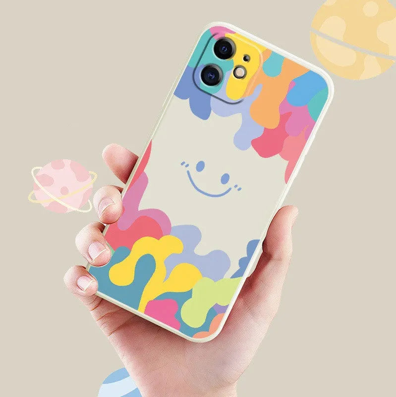 White silicone phone case with a rainbow smiley face design and a black lanyard attached.