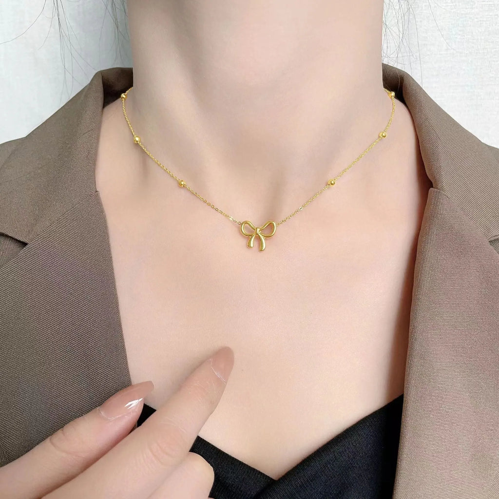 Gold electroplated bow necklace on cross chain with adjustable 41-50cm length