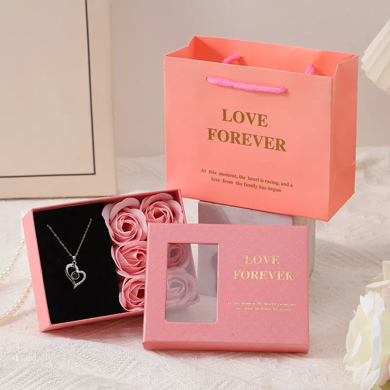 Six red soap flower roses in a black gift box with decorative handbag for Valentine's Day presents.