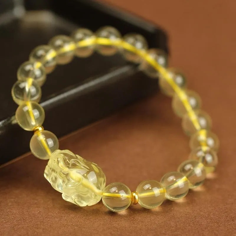 Yellow leather bracelet with artificial crystal beads and a Pi Xiu charm in simple Chinese style.