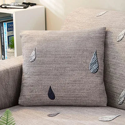 Stretchable geometric print sofa slipcover covering a three-seater sofa with matching pillow
