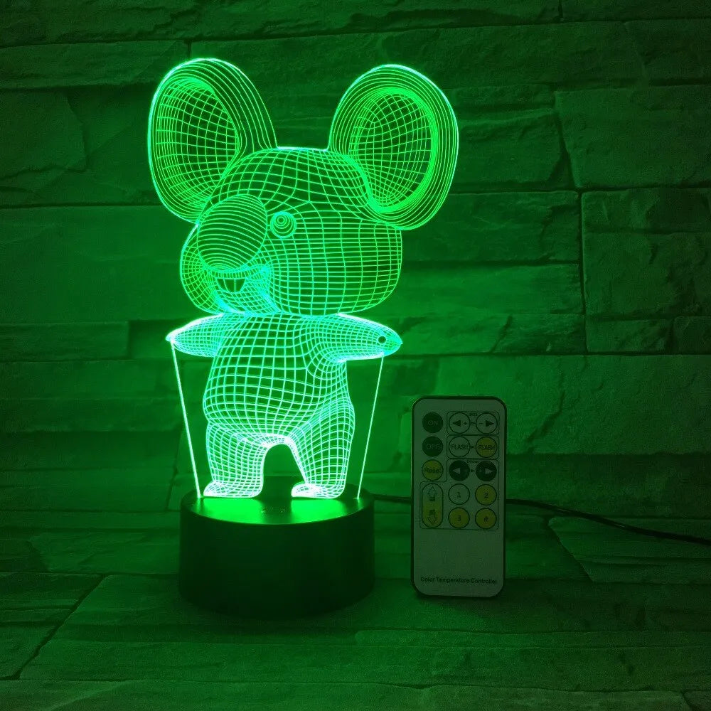 Black koala night light with colourful LED glow on a small table, showing remote control.