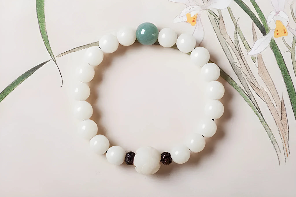 Natural white jade Bodhi bracelet with transfer beads on a neutral background