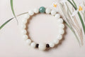 Natural white jade Bodhi bracelet with transfer beads on a neutral background