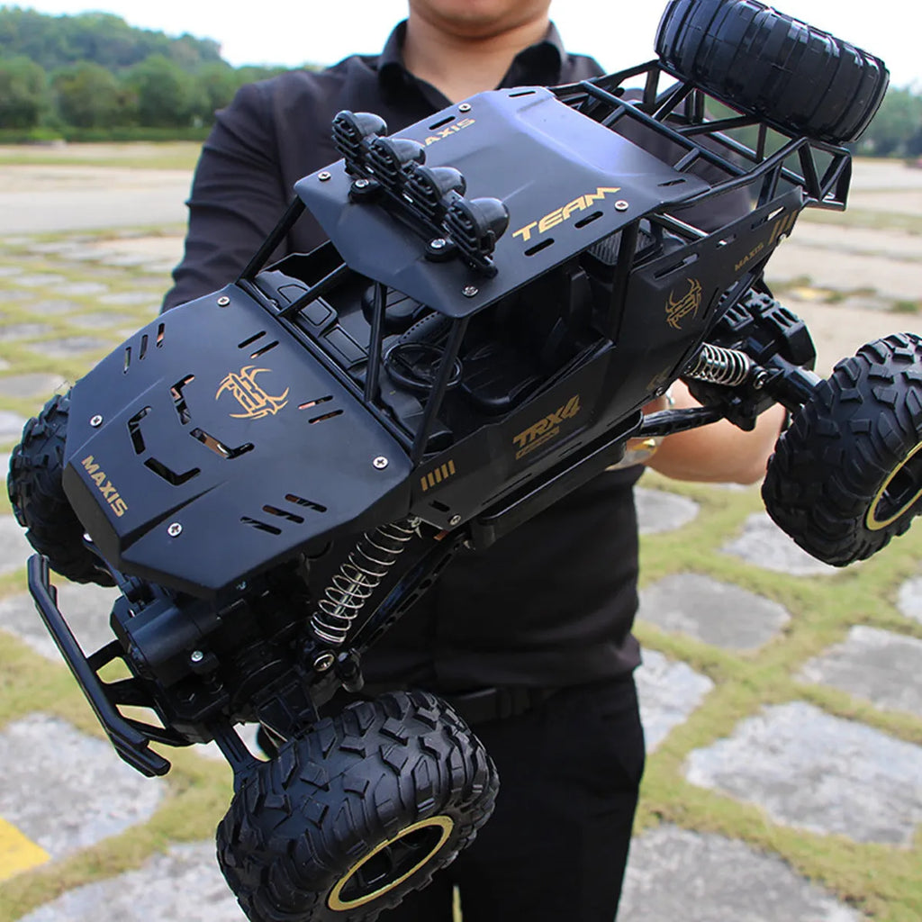 Black and silver 2.4G wireless remote control four-wheel drive car on a rough surface.