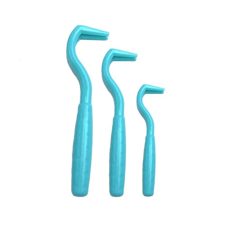 Set of three coloured tick removal hooks for dogs on a plain background.