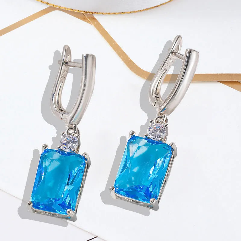 A pair of square gold and silver geometric electroplated earrings with a quadrilateral design.