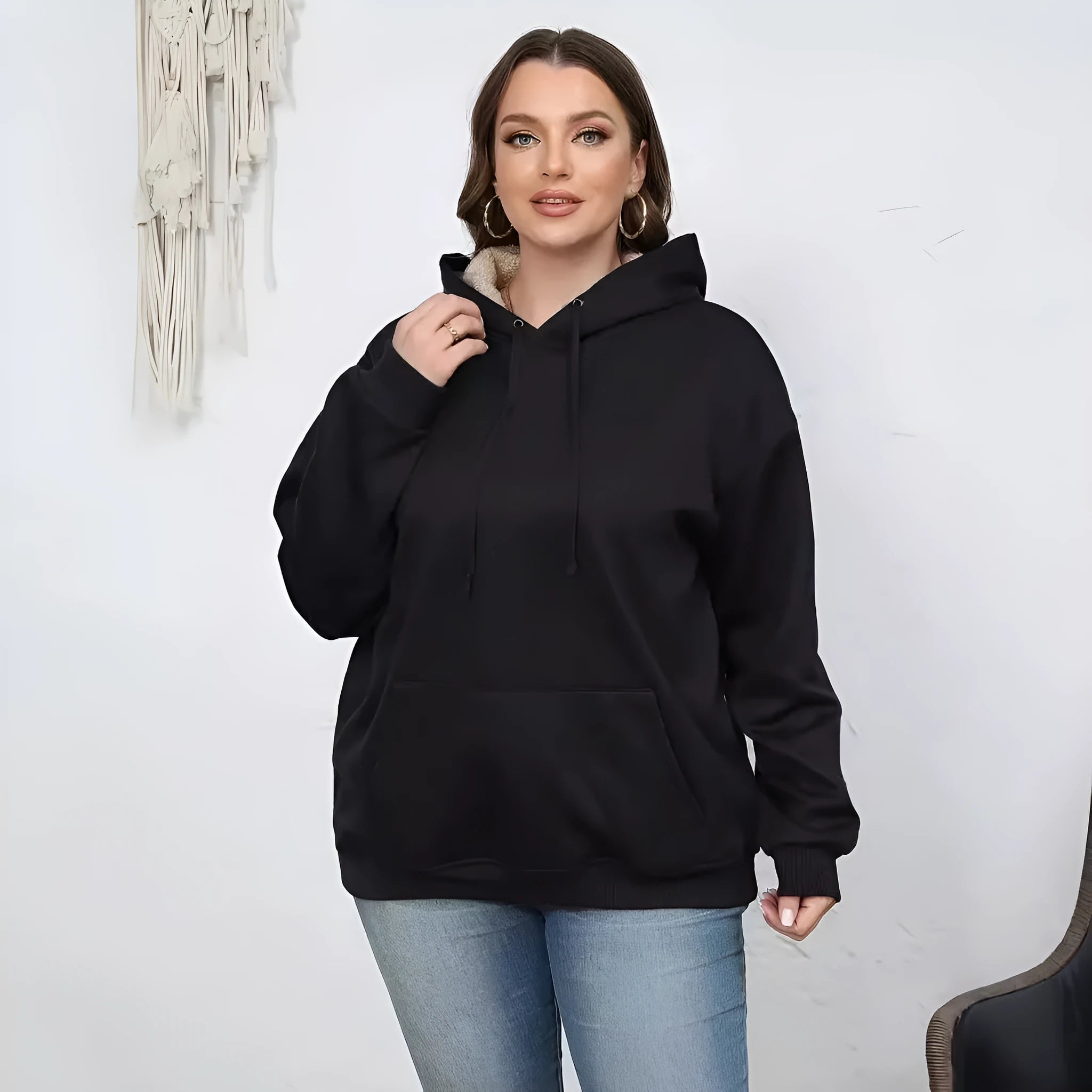 Women's black loose fit hooded sweater with pockets and long sleeves laid flat.
