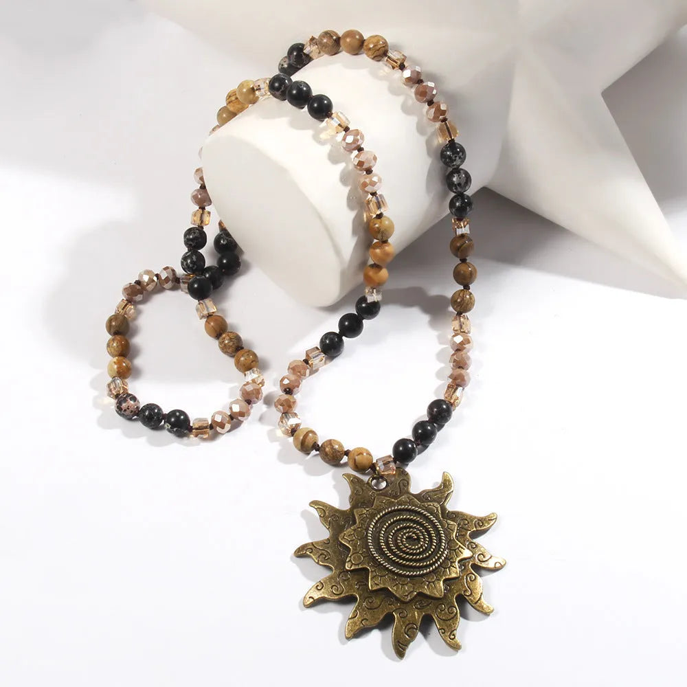 Natural stone beaded necklace with ancient cyan sun pendant and glass knotted chain in black or dark brown.
