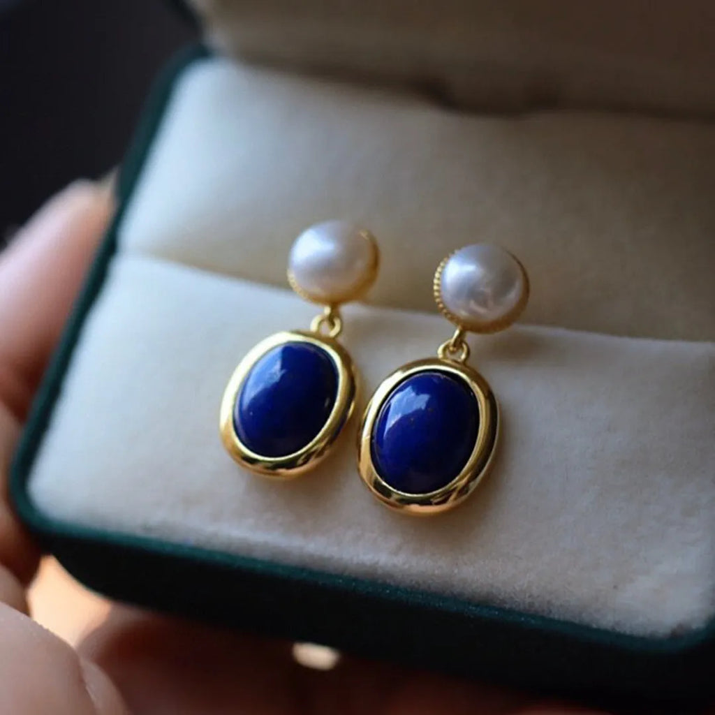 A pair of sterling silver earrings with deep blue lapis lazuli pearls and simple auspicious patterns.