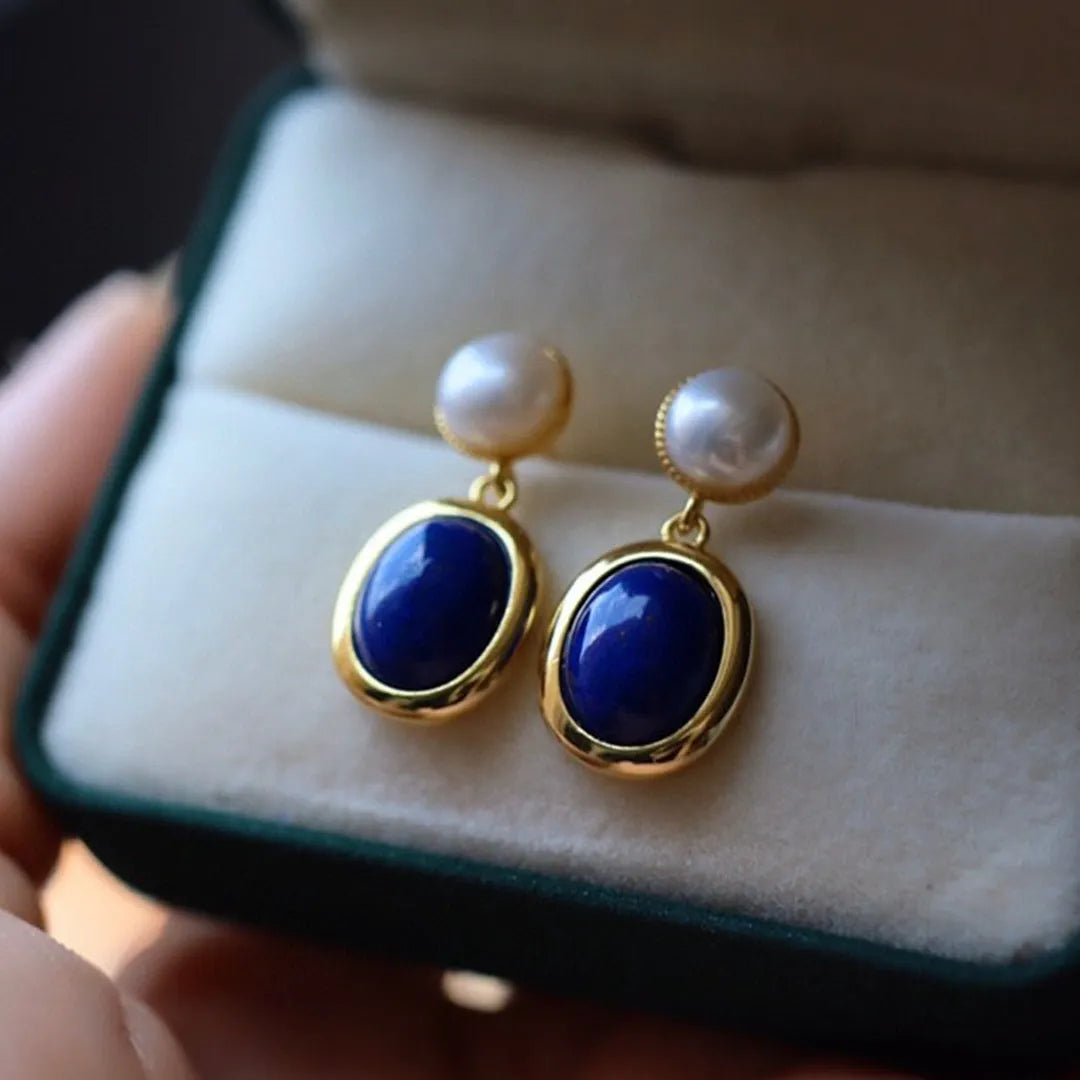 A pair of sterling silver earrings with deep blue lapis lazuli pearls and simple auspicious patterns.