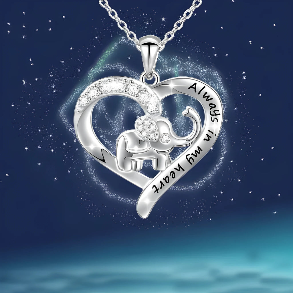 Silver alloy elephant pendant necklace with personalised letter charm on a flat surface