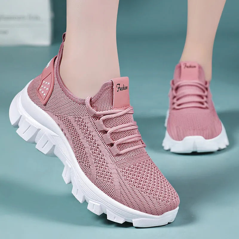 Women's white Flyknit lace-up sneakers with a thick PVC sole and round toe on a neutral background.