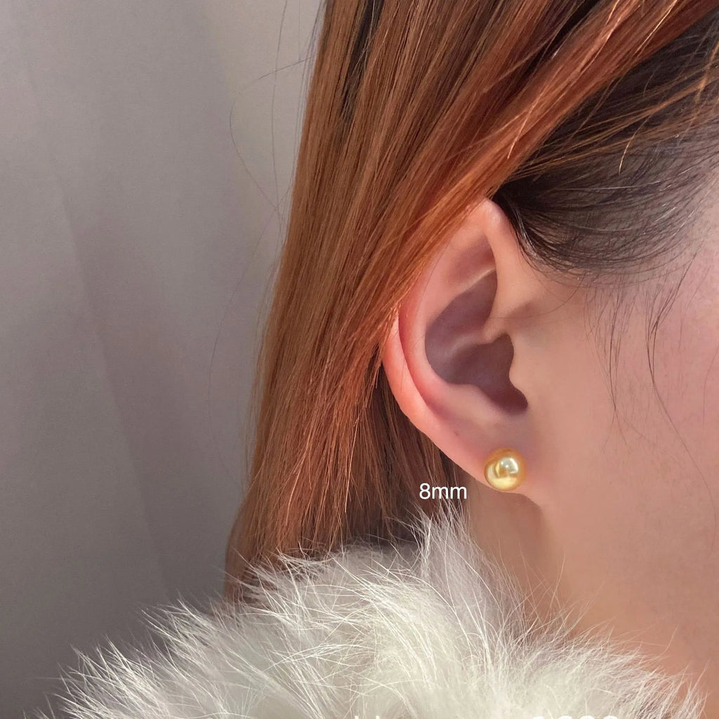 Large geometric pearl stud earrings for women in silver, showing eight-point star detail on setting.
