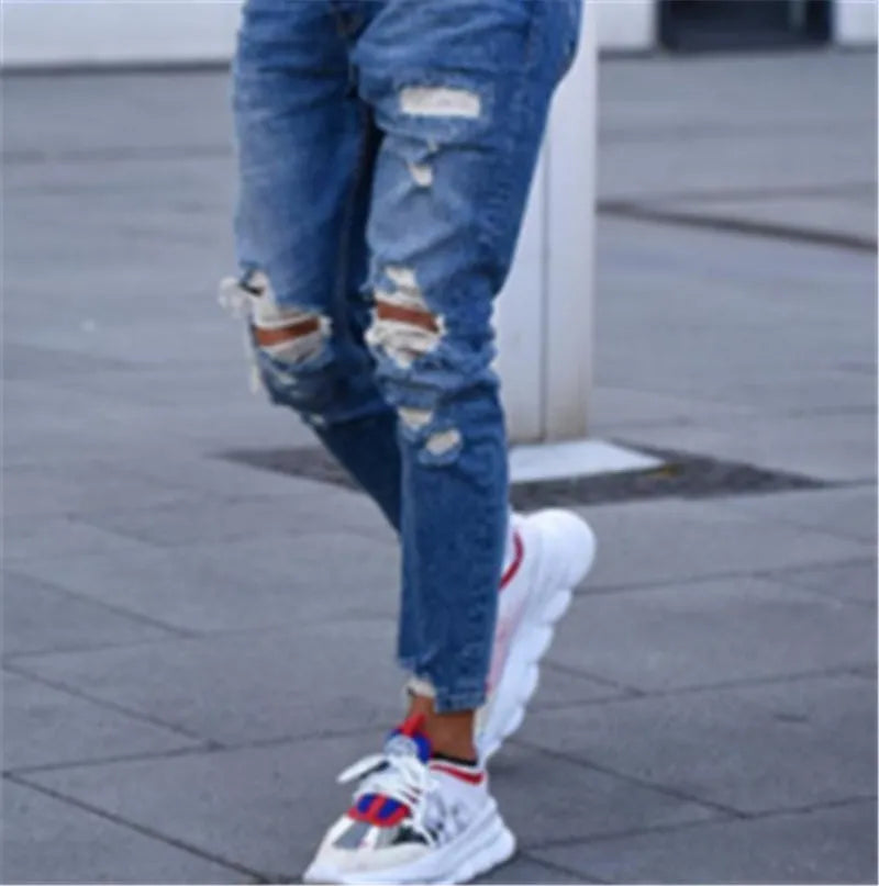 Deep blue men's jeans showing distressed hole details on the legs