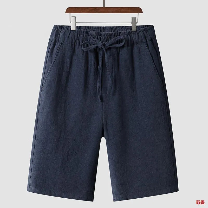 Man wearing beige linen cropped shorts with a loose fit and elasticated waistband.