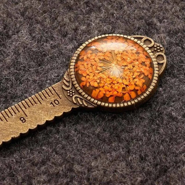 Handmade dried flower bookmark ruler with gypsophila, lace flowers, and clover, 12cm long on a book page.