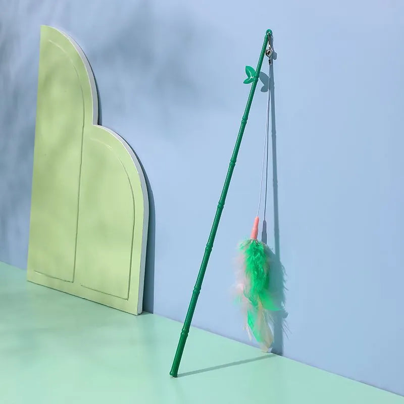 Green interactive cat feather wand toy with bells attached for indoor play and training