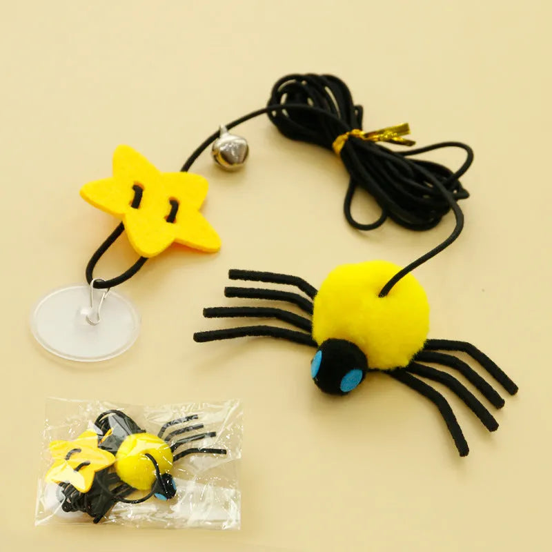 Red and yellow cat toy with feather and bell spider hanging from a door on an elastic rope.