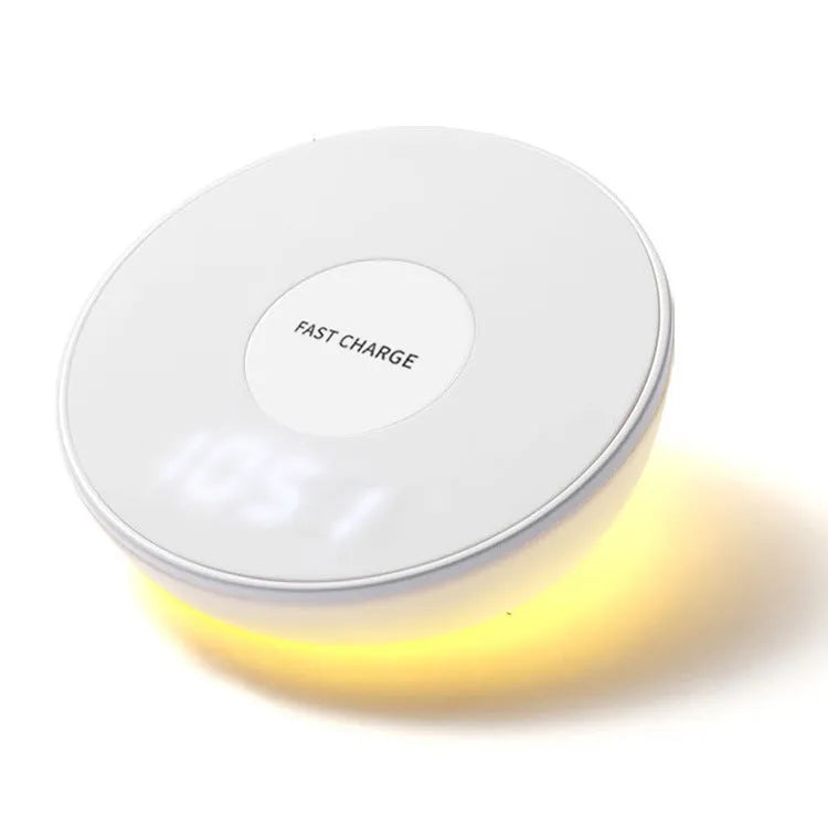 White wireless charging pad with LED digital clock display and control buttons on a desk.