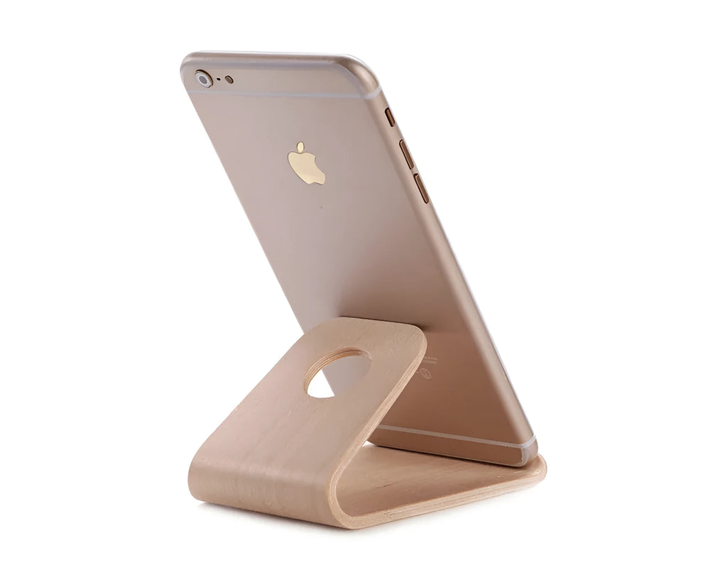 A wooden phone stand holding an iPhone in landscape mode on a desk.