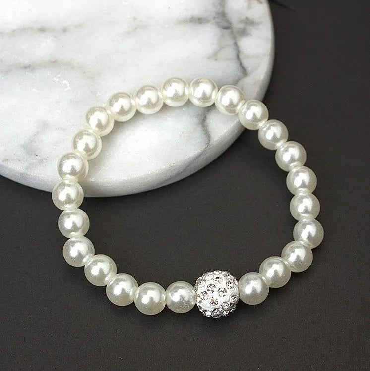 White plastic resin pearl-style jewellery set including necklace, earrings, and bracelet on display