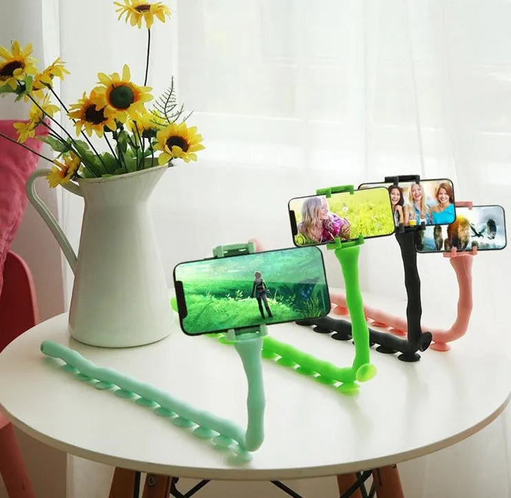 Flexible rubber phone holder with suction cup mounted on a surface showing 360-degree rotation capability