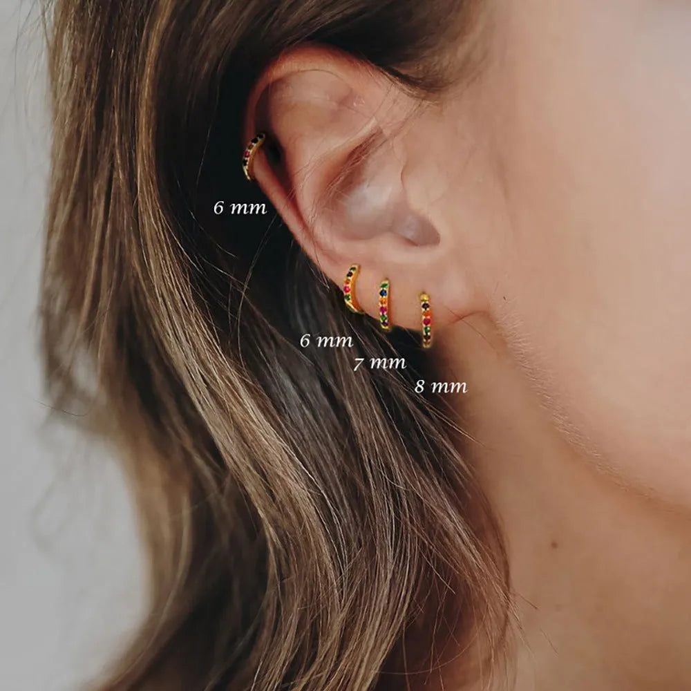 Circle-shaped zircon stud earrings in gold, rose gold, or silver colour on a white background.